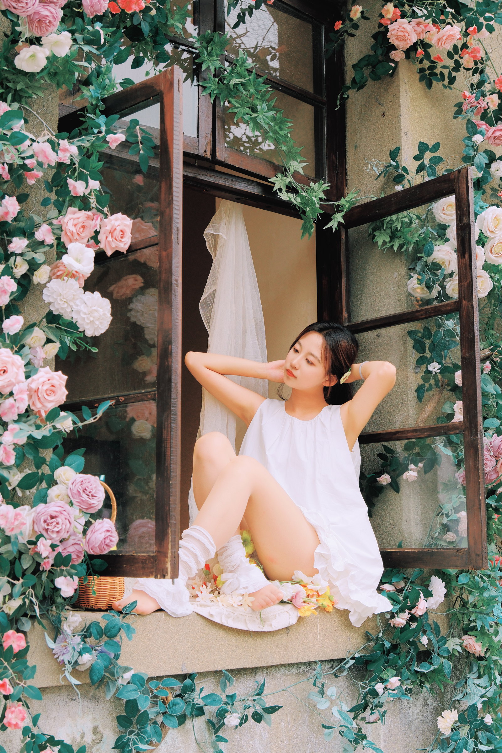 女子坐在布满花朵的窗前